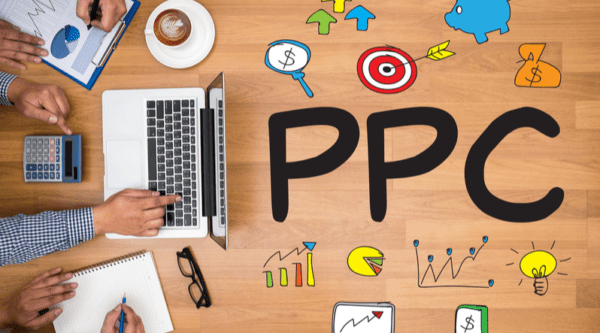 PPC - Pay Per Click concept Business team hands at work with financial reports and a laptop